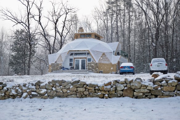 snow on a geodesic dome and rock wall