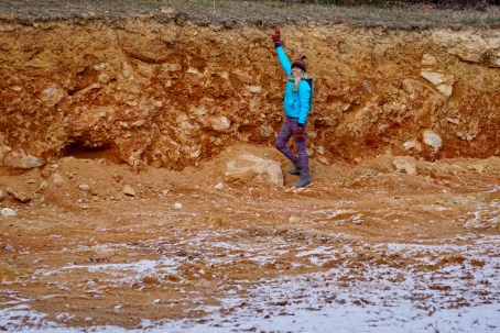 girl standing in excavated housepad in snow