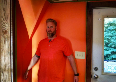 man in front of orange wall