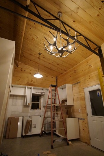 new construction IKEA kitchen installation in mountain cabin with antler chandelier