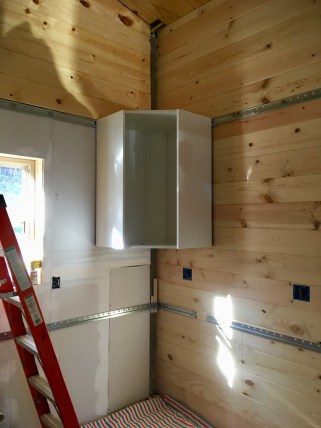 one IKEA cabinet hung by tongue & groove wall