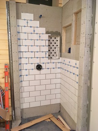 new construction shower being tiled
