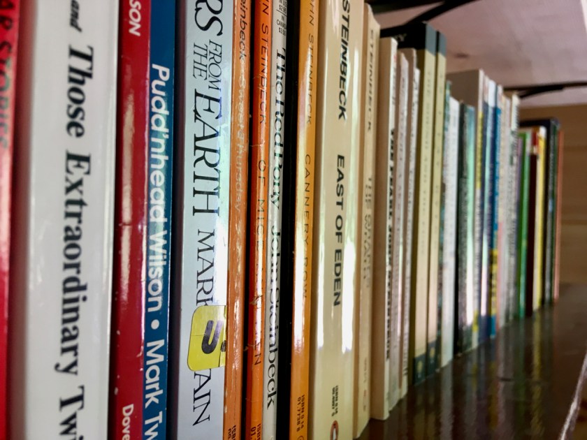 Mark Twain and Steinbeck books on a shelf