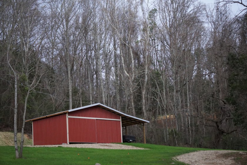 red metal polebarn on a hill