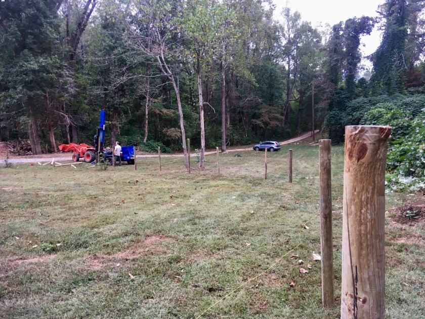 man completing a fence with a post driver