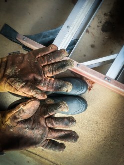 work gloves on boots with ladder