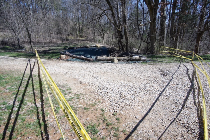 sinkhole covered by giant tarp surrounded by caution tape