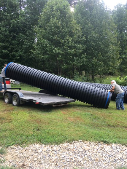 men unloading conduit from trailer