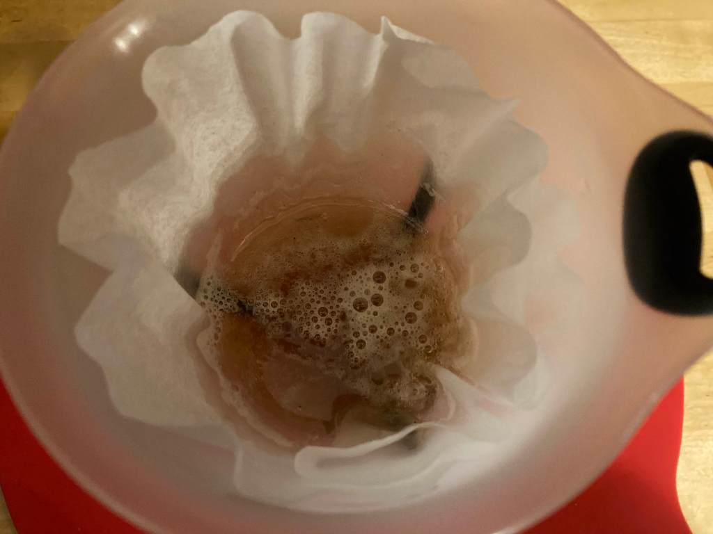 freshly boiled sap in coffee filter in funnel